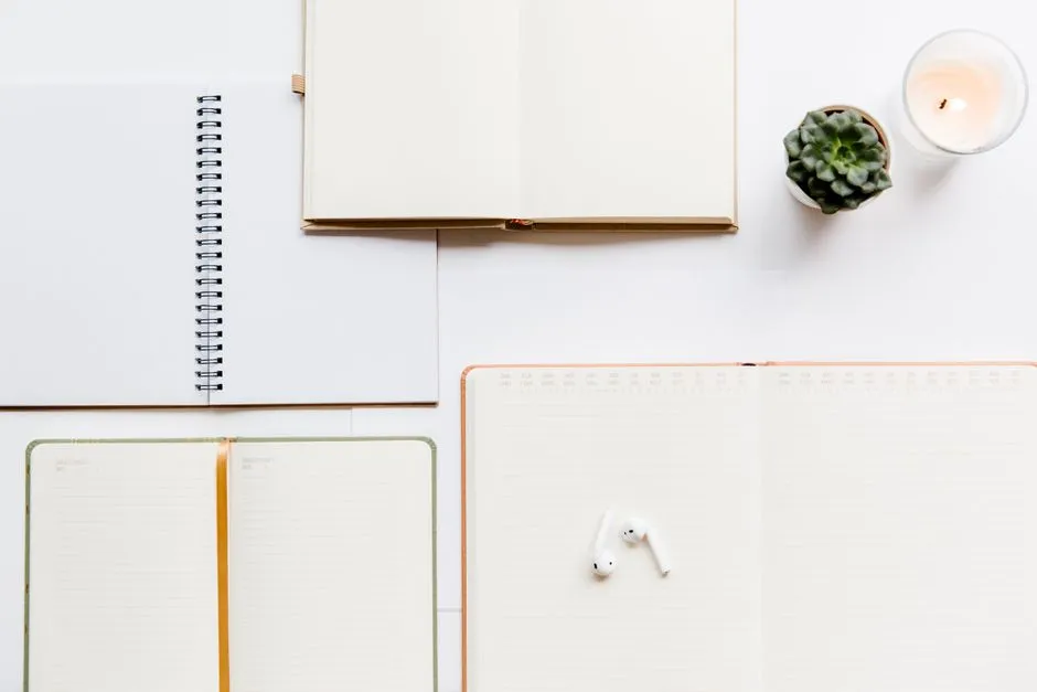 An overhead view of a printed planner page next to a candle on a desk, illustrative of a calm planning setup.